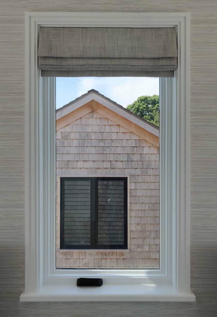 Window view of house with cedar shingles