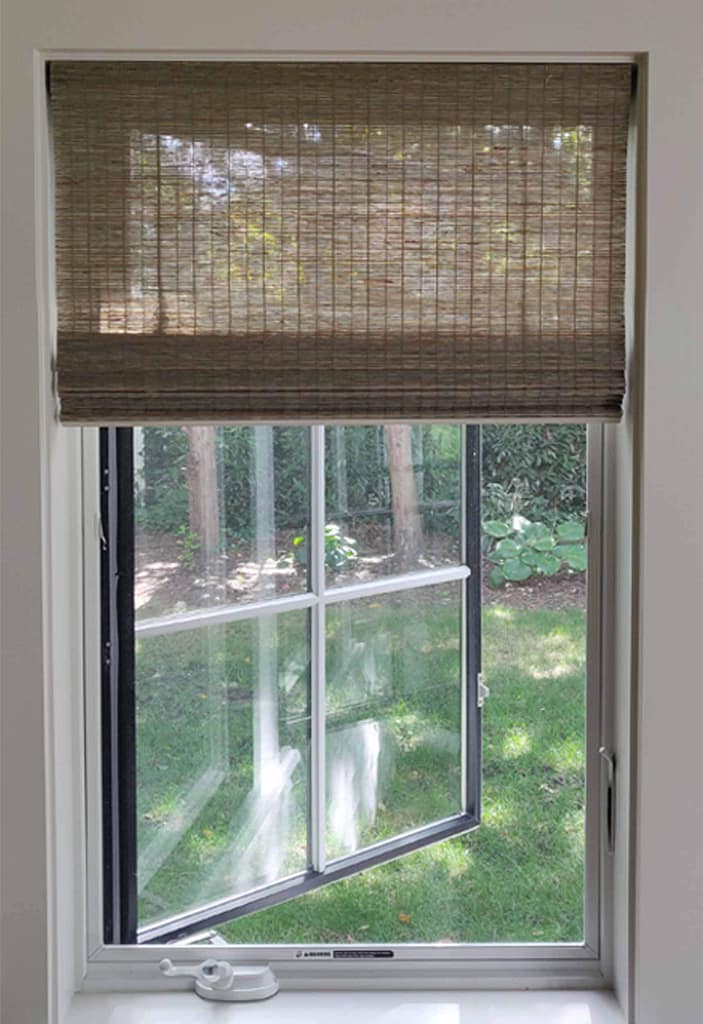 Open window with bamboo roller blind.