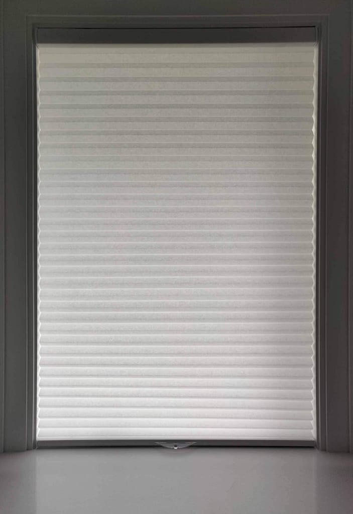 White window blind fully closed in room