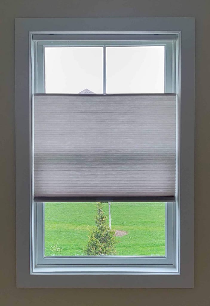Window with partially closed roller blind