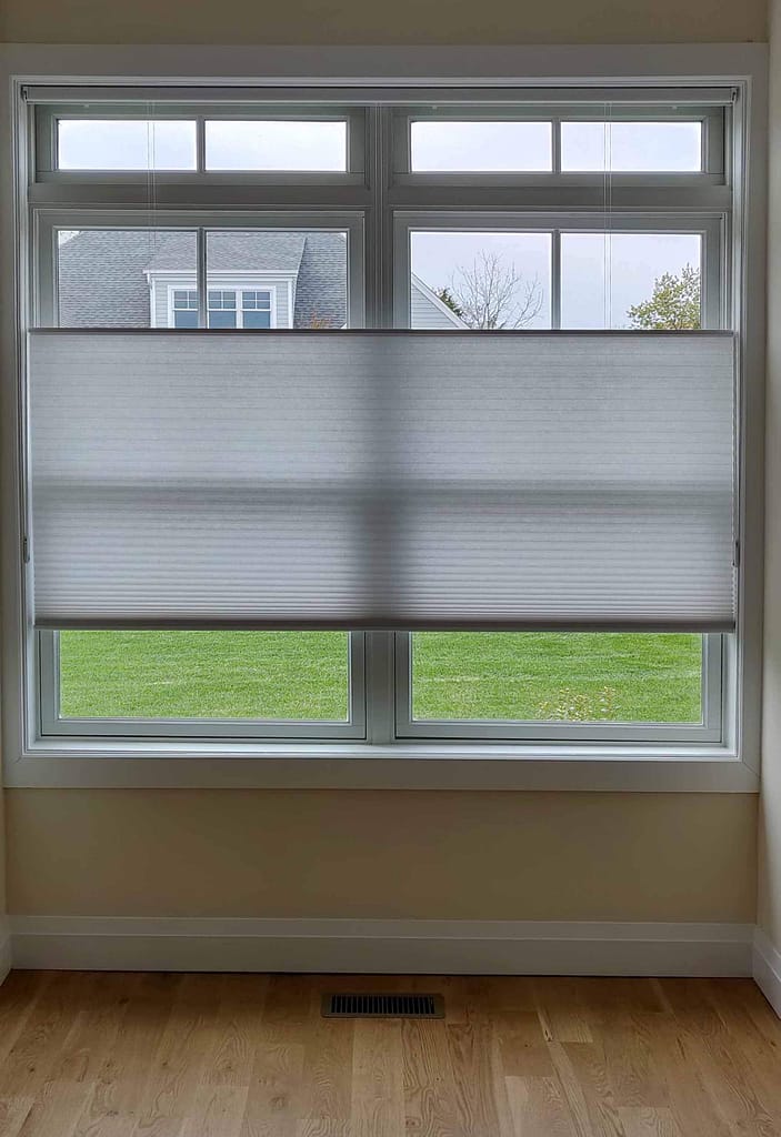 Window with half-lowered cellular blinds indoors