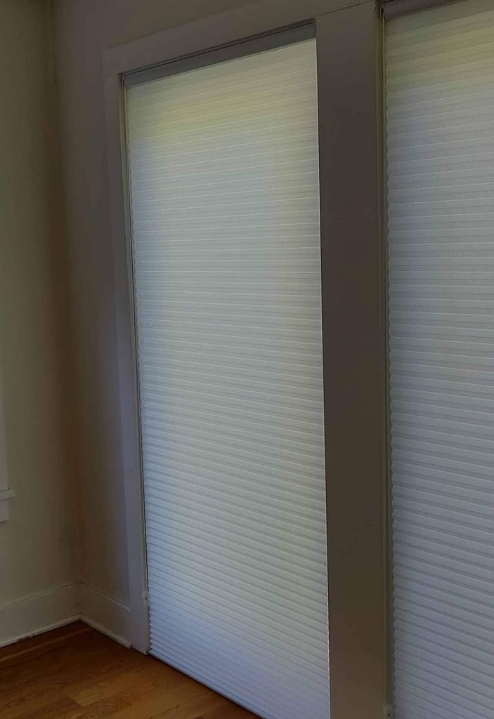 Closed white blinds on glass sliding door