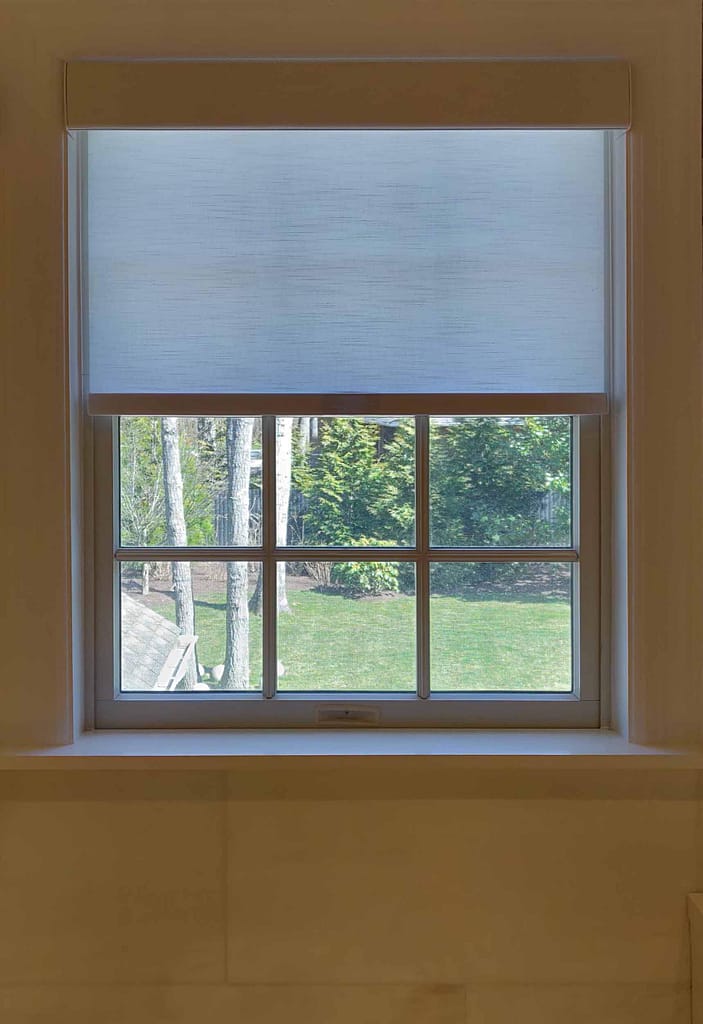 Sunny garden view through a window blind
